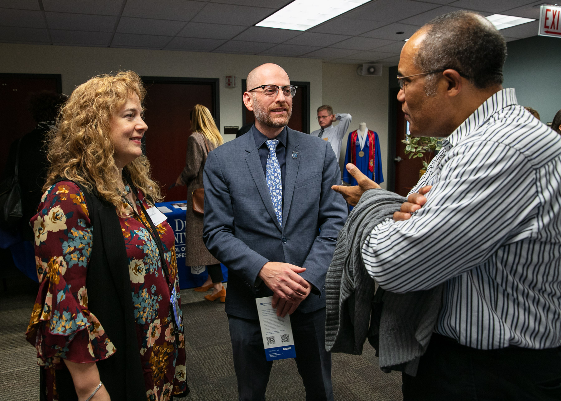 Caroline Kisel, assistant professor, left, and Don Opitz, interim dean for the School of Continuing and Professional Studies, converse with an attendee during the open house event. (DePaul University/Randall Spriggs) 